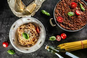 spaghetti bolognese con ingredienti basilico pomodori parmigiano formaggio e oliva olio foto