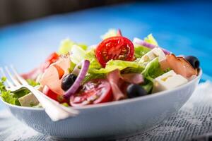 insalata. fresco estate lattuga insalata.sano mediterraneo insalata olive pomodori parmigiano formaggio e prosciutto foto