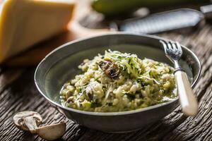 italiano risotto zucchine funghi e parmigiano nel buio piatto foto