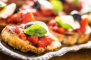 Bruschetta crostini con Mozzarella pomodori olive e basilico. foto