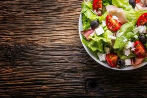 insalata. fresco estate lattuga insalata.sano mediterraneo insalata olive pomodori parmigiano formaggio e prosciutto. foto