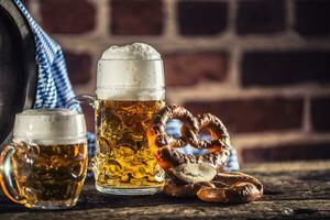 oktoberfest grande e piccolo birra con salatino di legno barile e blu tovaglia foto