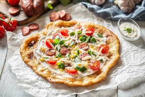 tradizionale ungherese combo fatto di in profondità fritte croccante langos con aglio bordi, precisamente servito con crema, grattugiato formaggio, pomodori e domestico salsicce anche con extra crema nel poco ciotola foto