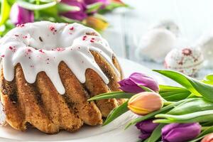 festivo Pasqua marmo torta con glassatura zucchero decorato a mano uova e primavera tulipani foto
