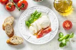 Mozzarella formaggio pomodori basilico e oliva olio. caprese insalata - italiano o mediterraneo pasto o aperitivo foto