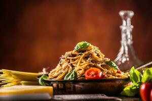 italiano pasta spaghetti con pomodoro salsa oliva olio basilico e parmigiano formaggio nel vecchio padella foto