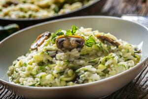 italiano risotto zucchine funghi e parmigiano nel bianca piatto foto