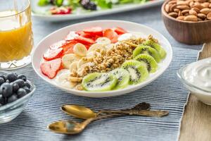 salutare prima colazione servito con piatto di Yogurt muesli Kiwi fragole e Banana foto