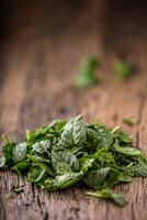 spinaci foglie.fresche spinaci le foglie nel retrò ciotola su quercia legna tavola. selettivo messa a fuoco. foto