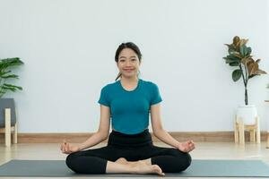 sottile donna praticante yoga su camera di sua condominio o casa. asiatico donna fare esercizi nel mattina. equilibrio, meditazione, rilassamento, calma, bene Salute, felice, relax, salutare stile di vita, dieta, sottile foto