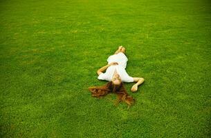 un' donna posa su il erba nel un' campo foto