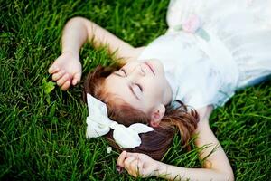 un' giovane ragazza posa nel il erba foto