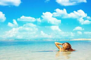 bellissimo donna nel bikini dire bugie su il spiaggia foto