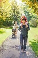 un' uomo e un' bambino a piedi nel un' parco con un' donna foto