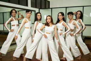un' gruppo di asiatico ballerini balli con loro amici mentre indossare bianca Abiti su il danza pavimento foto