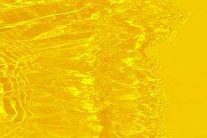 d'oro acqua con increspature su il superficie. defocus sfocato trasparente oro colorato chiaro calma acqua superficie struttura con spruzzi e bolle. acqua onde con splendente modello struttura sfondo. foto