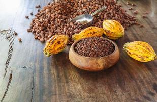 pennini di cacao e frutta di cacao su tavola di legno foto