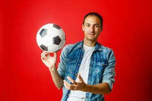 bello uomo Tenere un' calcio palla al di sopra di colorato backgound foto