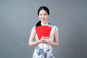 la donna asiatica indossa un abito tradizionale cinese con una busta rossa o un pacchetto rosso