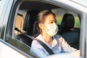 bella donna asiatica che guida un'auto indossando una maschera facciale che esce rimane in buona salute protettiva dal virus covid-19 del coronavirus
