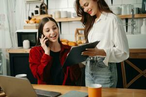 Due attività commerciale lavoratori parlando su il smartphone e utilizzando il computer portatile a il ufficio. foto