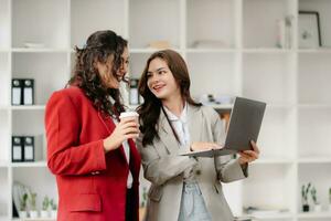 donna d'affari principale squadra incontro e utilizzando tavoletta e il computer portatile computer con finanziario nel coworking ufficio foto