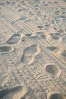 il sfondo di un' sabbioso spiaggia con impronte. sabbia spiaggia sfondo foto