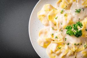 ravioli di pasta con salsa di crema di funghi e formaggio - stile italiano foto