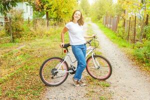 giovane donna equitazione bicicletta nel estate città parco all'aperto. attivo le persone. fricchettone ragazza rilassare e ciclista bicicletta. Ciclismo per opera a estate giorno. bicicletta e ecologia stile di vita concetto. foto