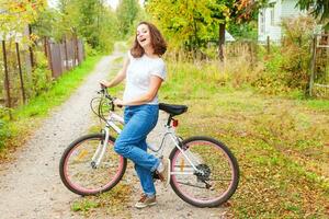 giovane donna equitazione bicicletta nel estate città parco all'aperto. attivo le persone. fricchettone ragazza rilassare e ciclista bicicletta. Ciclismo per opera a estate giorno. bicicletta e ecologia stile di vita concetto. foto