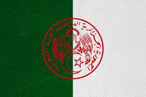 bandiera e cappotto di braccia di il algerino persone democratico repubblica su un' strutturato sfondo. concetto collage. foto