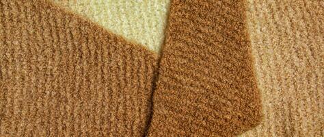 a maglia lana tessile con sfondo struttura nel leggero beige cremoso Marrone ombra. beige colore pendenza su struttura sfondo. sciarpa. foto