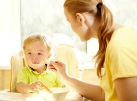 il poco ragazzo è mangiare porridge foto