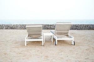 lettini bianchi sulla spiaggia. vacanze vacanze estive sfondo. foto
