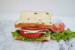 Sandwich con prosciutto, formaggio, pomodoro e lattuga sfondo foto