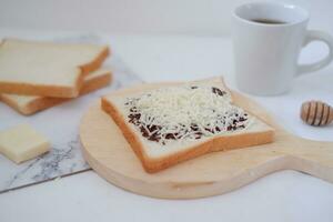 prima colazione con caffè, formaggio e pane su bianca marmo tavolo. foto