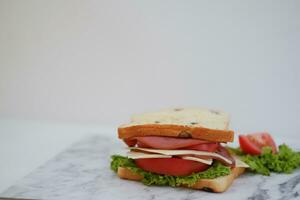 Sandwich con prosciutto, formaggio, pomodoro e lattuga sfondo foto