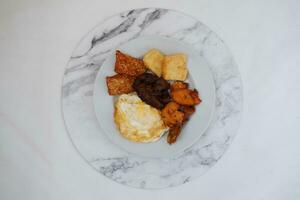 fritte tofu con fritte uovo e arachide salsa su bianca marmo tavolo foto