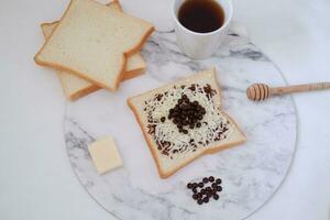 prima colazione con caffè e crostini su bianca marmo tavolo, azione foto