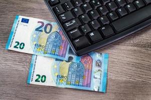 Banconote da 20 euro e tastiera del computer foto