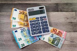 banconote di diverso taglio in euro e calcolatrice foto