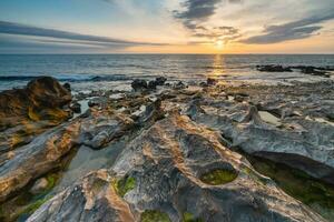 tramonto a il roccioso spiaggia a vila nova de Gaia, Portogallo. foto