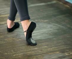 vicino su Visualizza per ballerine gambe nel pointes su di legno pavimento foto