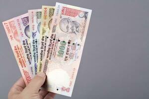 vecchio indiano i soldi - rupia nel il mano su un' grigio sfondo foto