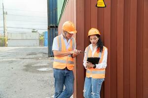 manutenzione lavoratore Lavorando con carico contenitori. ingegnere nel sicurezza casco, riflessivo veste, Tenere walkie talkie con contenitore esportare e importare attività commerciale e la logistica sfondo. foto