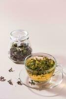 fresco caldo tè con origano nel un' tazza e asciutto erba nel un' barattolo. erbaceo medicina e alternativa terapia. verticale Visualizza foto