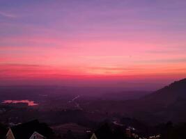 arancia e rosa cielo crepuscolo tramonto nel mattina dietro a montagna inferiore nebbia copertina verde foresta fresco aria foto