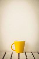 tazza di caffè gialla sul tavolo foto