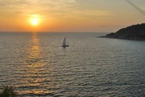 un' yacht a tramonto su il mare superficie. tramonto con un' di yacht silhouette, Tailandia foto