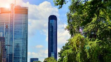 riflessione di moderno commerciale edificio su bicchiere con luce del sole. eco architettura. verde albero e bicchiere ufficio costruzione. il armonia di natura e modernità. foto